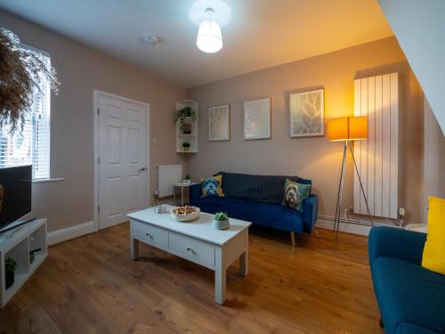 a living room with a blue couch and a coffee table at Whole Town House - Town centre! in Tamworth