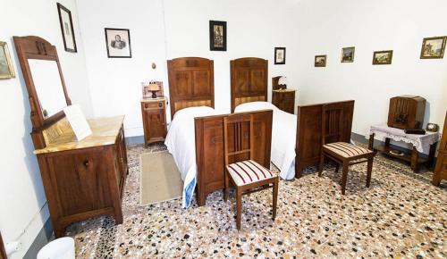 a bedroom with a bed with wooden furniture and two chairs at B&b Villa Bornancini in Cinto Caomaggiore