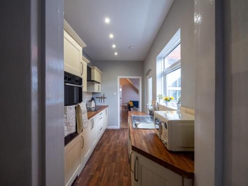 a kitchen with a sink and a microwave at Whole Town House - Town centre! in Tamworth