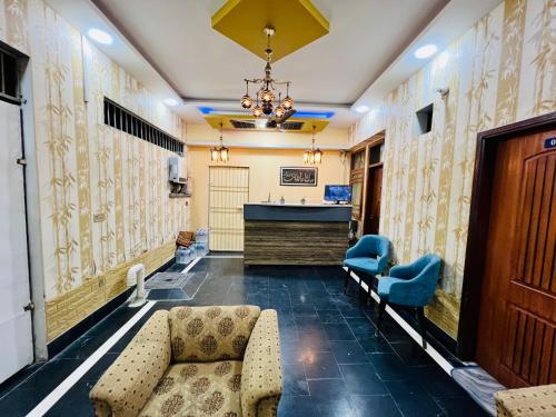 a lobby with a waiting room with a couch and chairs at Karachi Inn PECHS in Karachi