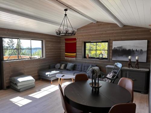 ein Wohnzimmer mit Tisch und Couch in der Unterkunft Modern Cozy Cabin Near Langsua National Park in Heggenes