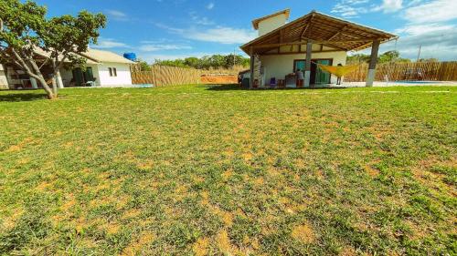 a yard with a house and a grass field at Vila Arcanjo in Santana do Riacho