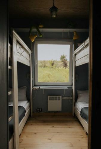 a small room with two beds and a window at Strefa Warmia in Wawrowice