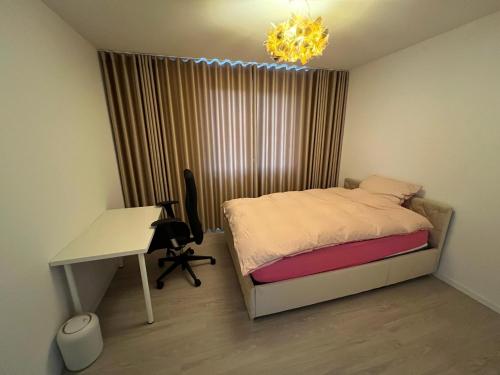 a bedroom with a bed and a desk and a chandelier at Premium Room near S-Bahn Station in Berlin
