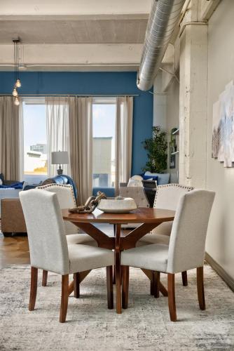 a dining room with a wooden table and white chairs at Spacious 1BR loft with flexible group sleeping in Dallas