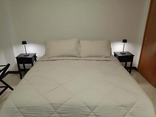 a large white bed with two nightstandiatesiatesiatesiatesiatesiatesiatesiates at Apartamento Remodelado 2 Habitaciones en la Mejor Zona del Centro de Caracas in Caracas