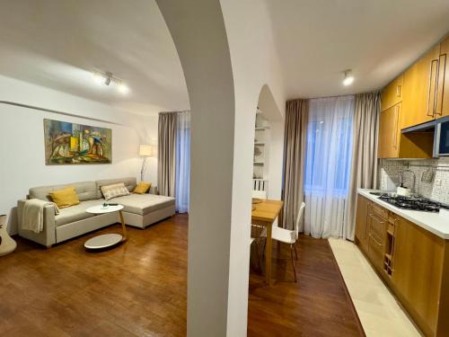 克拉约瓦English Park Residence的客厅里有一张沙发和一个厨房