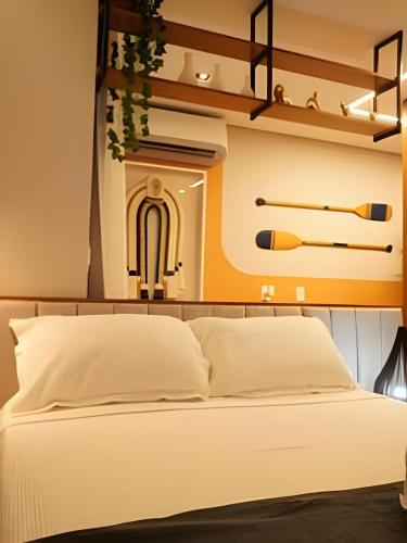 a bedroom with a white bed and shelves at Tiwa Studio Requinte Amazônico Adrianópolis in Manaus