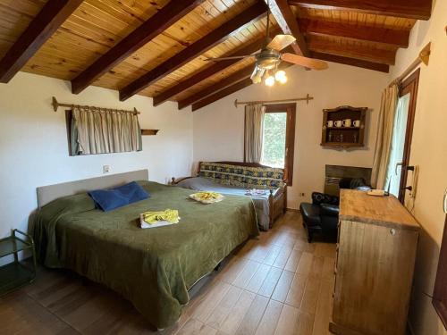 ein Schlafzimmer mit einem Bett und einem Deckenventilator in der Unterkunft Casa Familiar in La Cumbrecita