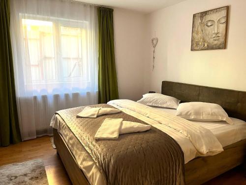 a bedroom with a bed with two towels on it at Rustic Breeze Azuga - BBQ, Fireplace and Parking in Azuga