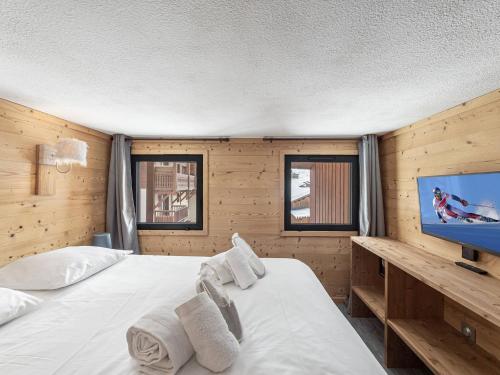 Un dormitorio con una cama grande y un televisor de pantalla plana. en Duplex rénové proche pistes, 6 pers, animaux bienvenus, Wi-Fi - FR-1-640-41, en Val Thorens