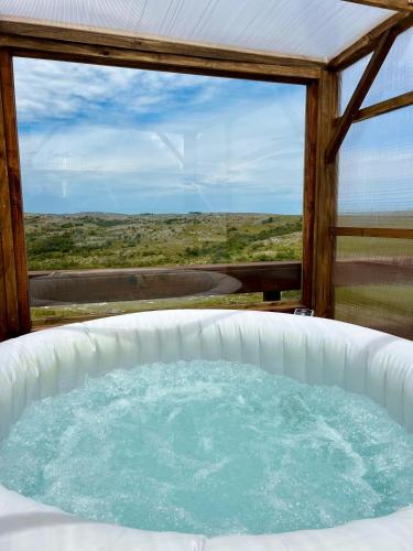 einen Whirlpool in einem Zimmer mit Aussicht in der Unterkunft Secreto Sierras Domos Boutique con Jacuzzi y Desayuno in Aiguá