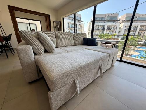 a couch in a living room with a large window at Modern Luxury Residency at Altea-Sunset Pool View in Puerto Vallarta