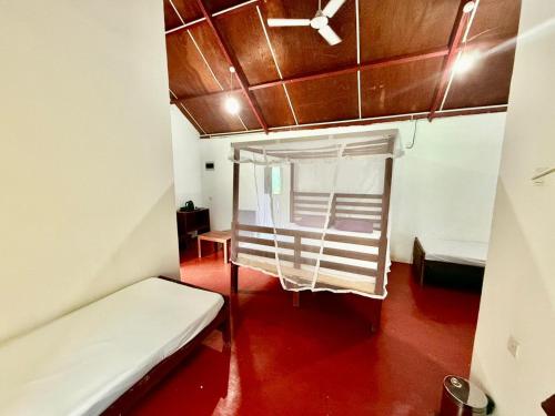 a small room with a bed and a ceiling at Sinharaja Forest Sanctuary in Deniyaya