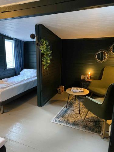 a bedroom with a bed and a table and a chair at Lærdalsøren Motor Guesthouse in Lærdalsøyri