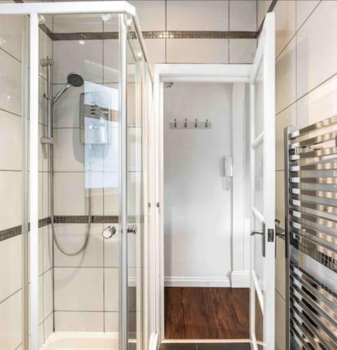 a shower with a glass door in a bathroom at Between Piers, the stylish studio flat in Cannon place in Brighton & Hove