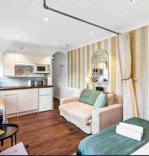 a living room with a couch and a kitchen at Between Piers, the stylish studio flat in Cannon place in Brighton & Hove