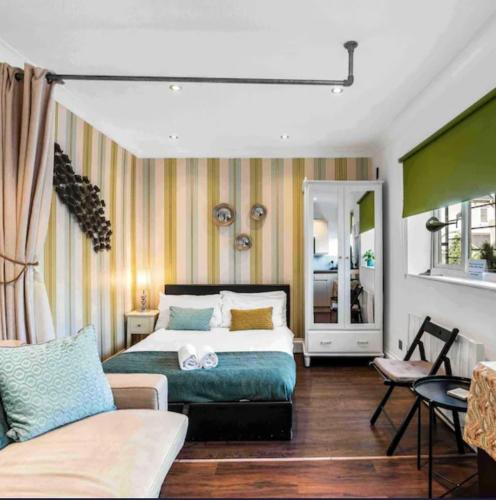 a bedroom with a bed and a couch at Between Piers, the stylish studio flat in Cannon place in Brighton & Hove