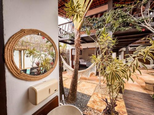um espelho na parede ao lado de uma sala com plantas em AKY JERI - POUSADA Vila de Jericoacoara em Jericoacoara