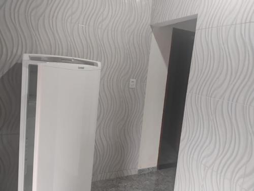 a room with a white wall and a doorway at Chalé alto valinhos in Itamonte