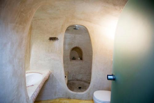 a bathroom with a tub and a sink and a toilet at Αura Cave in Fira