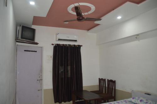 a room with a ceiling fan and a table and a bed at Hotel Vrindavan in Fatehpur Sīkri