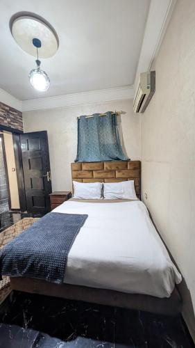 a bedroom with a large bed with a wooden headboard at Tayyurt Apartement city centre agadir in Agadir