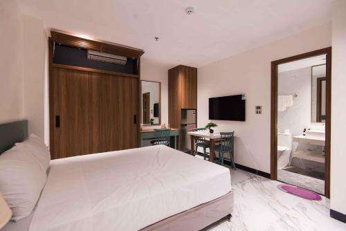 a bedroom with a large white bed and a bathroom at Paradise Boutique Hotel Hoàng Cầu in Hanoi