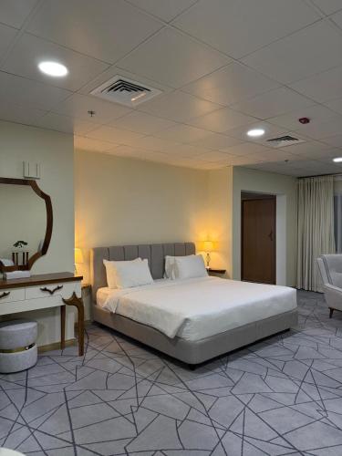 a bedroom with a large bed and a desk at Al Safa Royal Suites in Doha