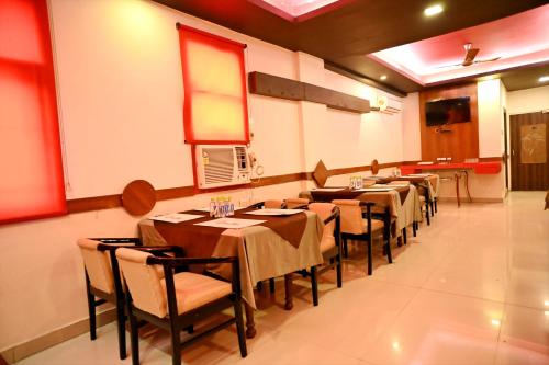 uma fileira de mesas e cadeiras em um restaurante em Citi Club em Kānpur
