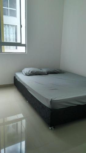 a bed in a white room with a window at Apartamento 2 habitaciones villavicencio in Villavicencio