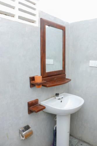 a bathroom with a sink and a mirror on the wall at Shehara Sun Surf Lodge in Midigama East