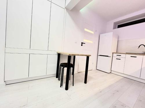 a white kitchen with a table and a refrigerator at Apartament Lubicz Dolny in Lubicz