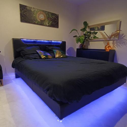 a bedroom with a bed with a blue light at Suite Zen Balnéo in Montpellier