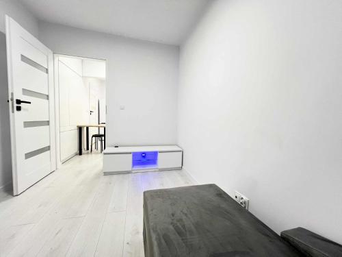 a white room with a bed and a table at Apartament Lubicz Dolny in Lubicz
