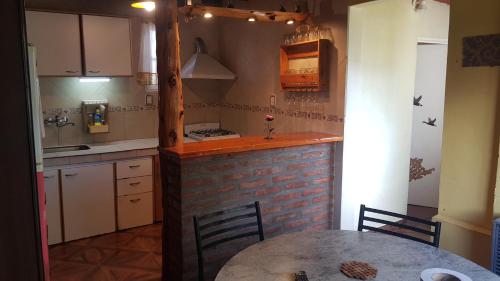 cocina con mesa y encimera de ladrillo en Mirador del Piltri, en El Bolsón