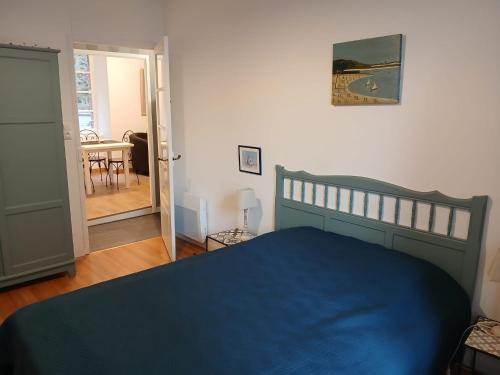 une chambre avec un lit bleu et une salle à manger dans l'établissement Granville hyper centre, à Granville