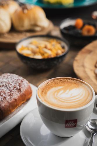a cup of coffee sitting on a table with pastries at Mare Hotel in Savona