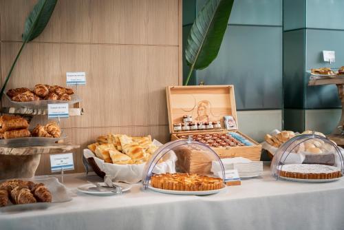 a table with various types of pastries and bread at Mare Hotel in Savona