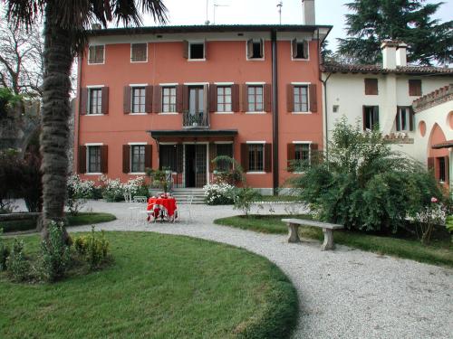 a large red building with a park in front of it at B&b Villa Bornancini in Cinto Caomaggiore