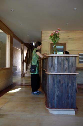 a woman is standing next to a large wooden table at Palafito 1326 Hotel Boutique Chiloé in Castro