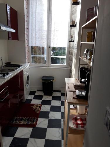 a kitchen with a checkered floor and a window at TINCHEBRAY Centre ville in Tinchebray