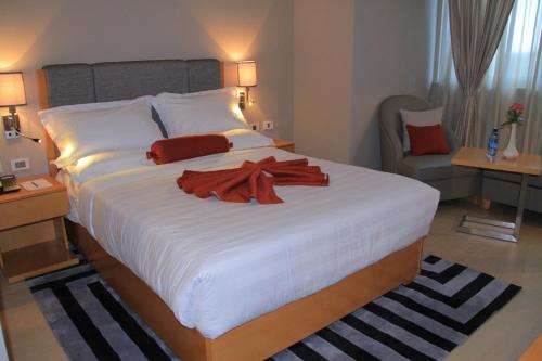 a bedroom with a large white bed with a scarf on it at Ambassador Hotel in Addis Ababa