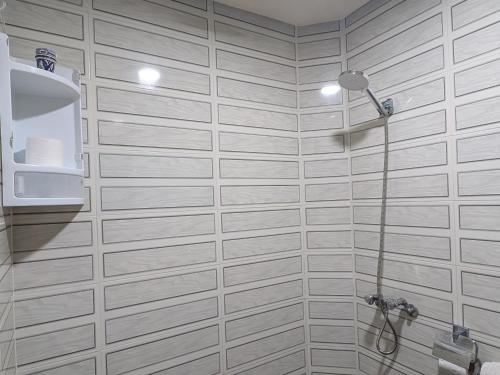 a bathroom with white tile walls and a shower at Tayyurt Apartement city centre agadir in Agadir