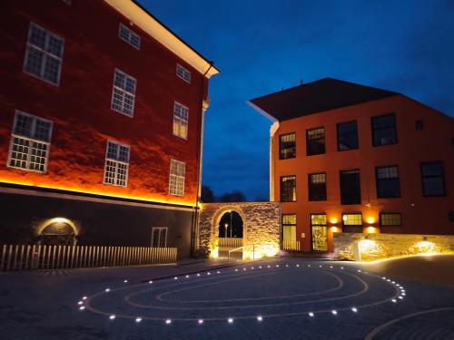 a night view of two buildings and a courtyard at Narva Boho Home in Narva