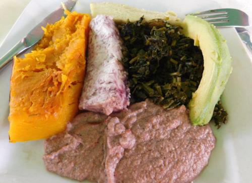 a plate of food with meat and vegetables and a fork at Javelin Palace Hotel in Kampala