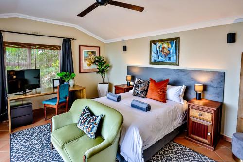 a bedroom with a bed and a desk and a chair at Villa Bel Fiori - 4 Bedroom Villa in Ballito
