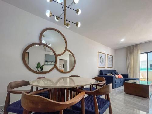een eetkamer met een tafel, stoelen en een spiegel bij Charming apartment 3 minutes from the beach in La Florida