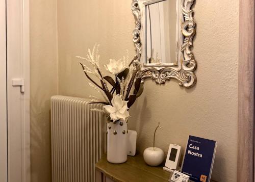 un jarrón con flores en una mesa junto a un espejo en Casa Nostra, en Aridaía