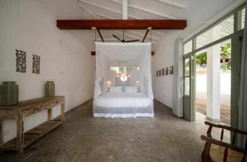 une chambre avec un lit à baldaquin dans l'établissement Villa Elise, à Sinimodera